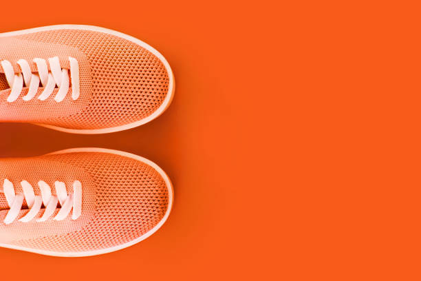 istock Bright orange sneakers on an orange background. 1042715710