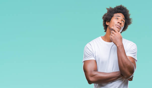 istock Afro american man over isolated background with hand on chin thinking about question, pensive expression. Smiling with thoughtful face. Doubt concept. 1042719796