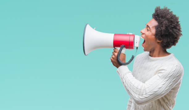 Young handsome afro american black man shouting through megaphone