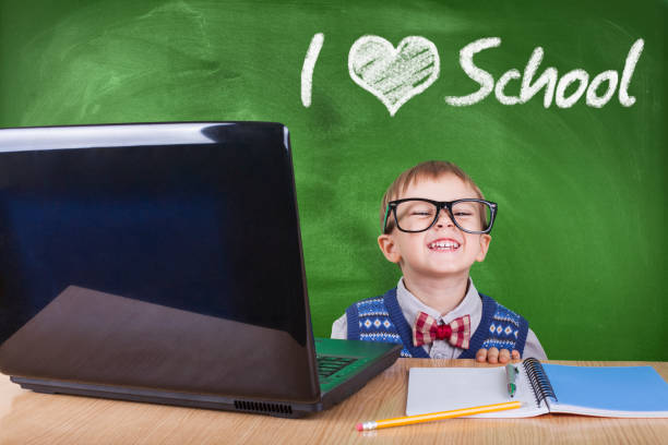 istock Child with laptop peeking in the classroom 1042723524