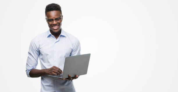 istock Young african american businessman using computer laptop with a happy face standing and smiling with a confident smile showing teeth 1042737598