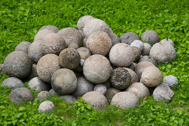 istock Medieval stone cannonballs on the grass 1042738020