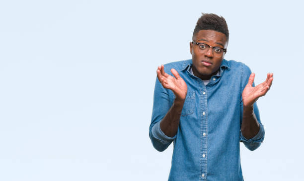 istock Young african american man over isolated background clueless and confused expression with arms and hands raised. Doubt concept. 1042741496