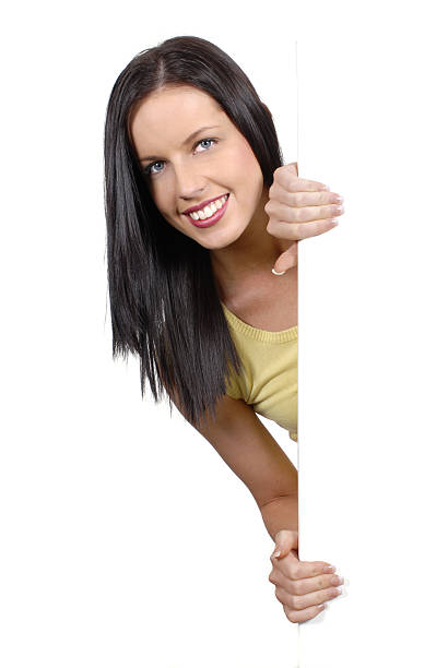 istock Friendly girl peeking round a white board 104274756