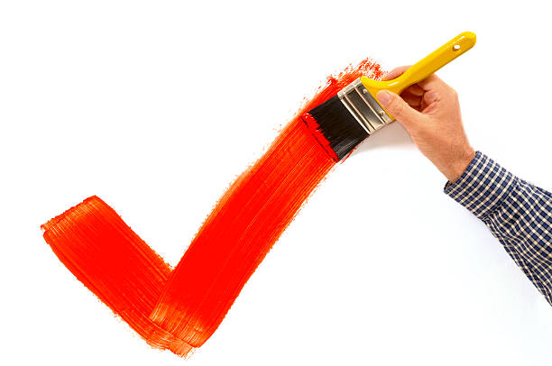 istock Man painting red checkmark on white wall 104275241