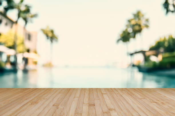 wood floor texture with blur summer background tropical resort hotel with blue pool water and palm tree - swimming pool resort swimming pool poolside sea imagens e fotografias de stock