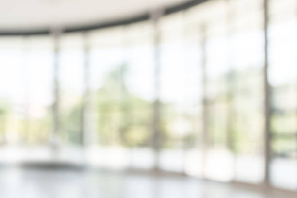 istock Blur background interior view looking out toward to empty office lobby and entrance doors and glass curtain wall 1042756488