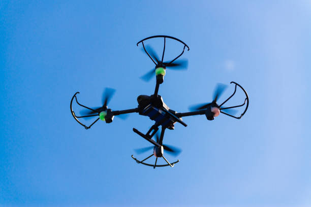 istock Flying drone or quad copter in blue sky. 1042756672
