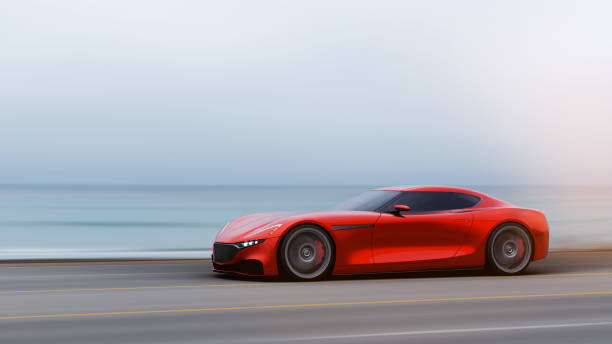 istock red car driving on a road by sea 1042759286