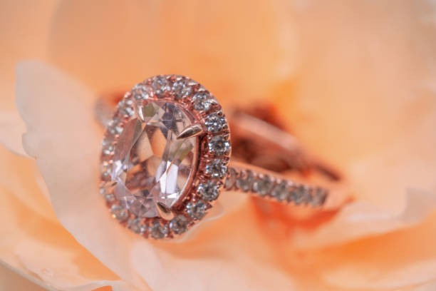 istock pink diamond ring on rose flower background 1042760362