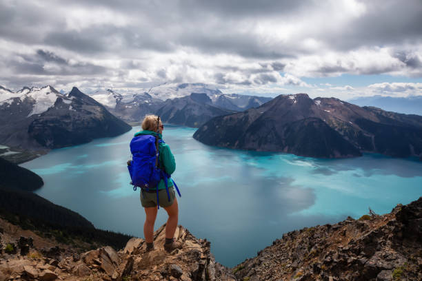 Girl hiking Panorama Ridge in Garibaldi Adventurous girl enjoying the beautiful Canadian Mountain Landscape during a vibrant summer day. Taken in Garibaldi Provincial Park, located near Whister and Squamish, North of Vancouver, BC, Canada. garibaldi park stock pictures, royalty-free photos & images