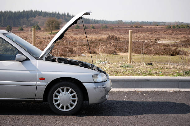 a gray car with its hood open parked by the side of the road - vehicle breakdown stockfoto's en -beelden