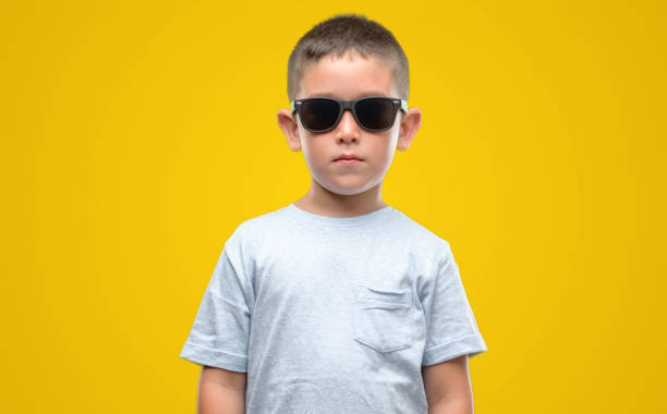 istock Dark haired little child wearing sunglasses with a confident expression on smart face thinking serious 1042793066