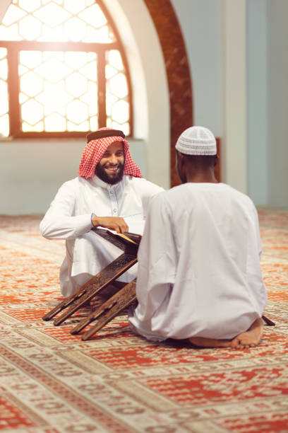 istock Muslim men praying with holy books in mosque 1042793608