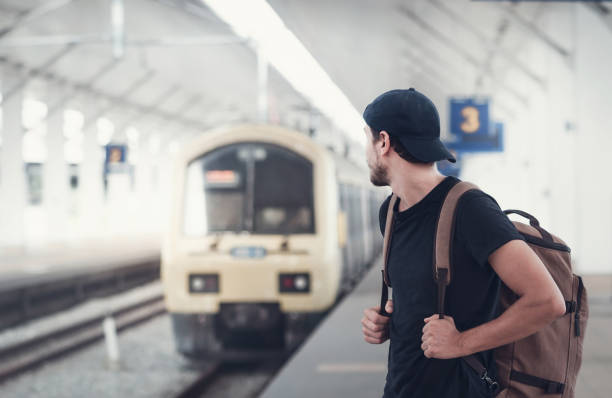 istock Young traveler walking with backpack on train staition and waiting train 1042796338
