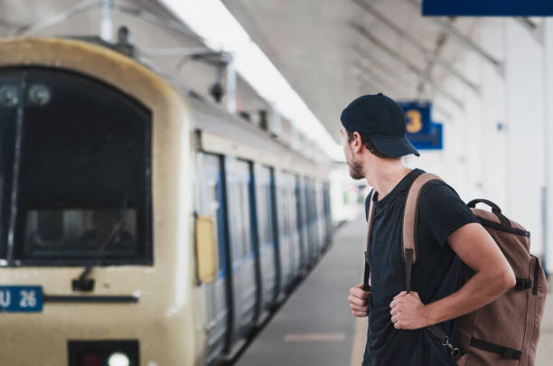 istock Young traveler walking with backpack on train staition and waiting train 1042796582