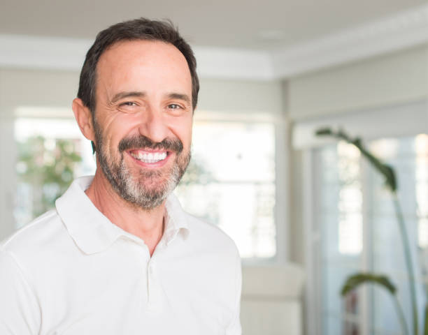 istock Handsome middle age man with a happy face standing and smiling with a confident smile showing teeth 1042799808