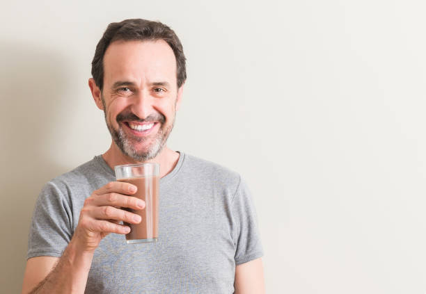istock Senior man drinking chocolate milk shake with a happy face standing and smiling with a confident smile showing teeth 1042800180