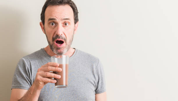 istock Senior man drinking chocolate milk shake scared in shock with a surprise face, afraid and excited with fear expression 1042800206