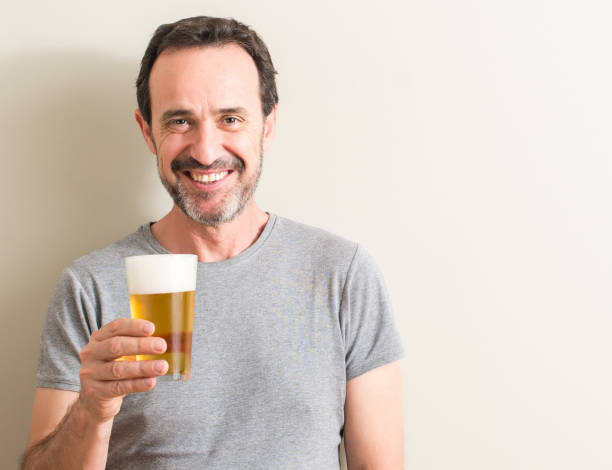 istock Senior man drinking beer with a happy face standing and smiling with a confident smile showing teeth 1042800236