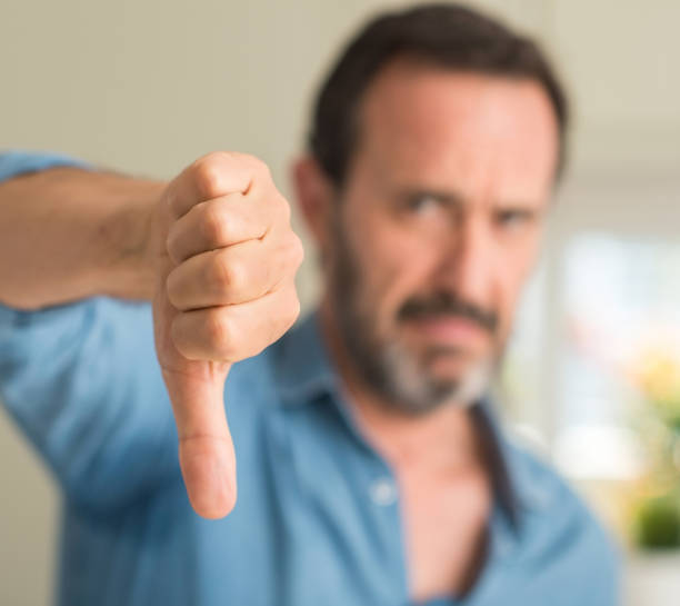 istock Handsome middle age man with angry face, negative sign showing dislike with thumbs down, rejection concept 1042800276