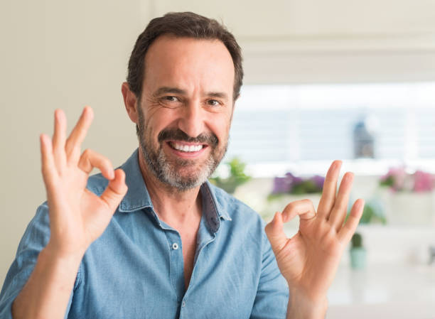 istock Handsome middle age man doing ok sign with fingers, excellent symbol 1042800294
