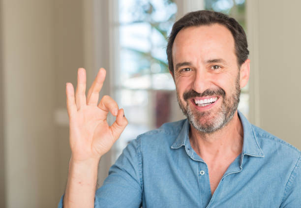 istock Handsome middle age man doing ok sign with fingers, excellent symbol 1042800302