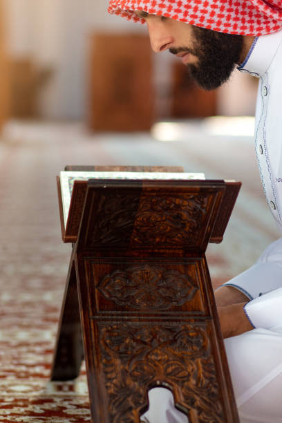istock Ethnic man reading Koran and praying in mosque 1042808198