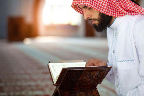 istock Ethnic man reading Koran and praying in mosque 1042808386