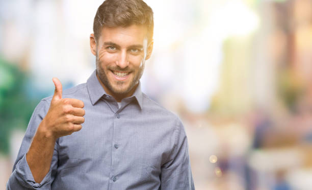 istock Young handsome man over isolated background doing happy thumbs up gesture with hand. Approving expression looking at the camera with showing success. 1042811930
