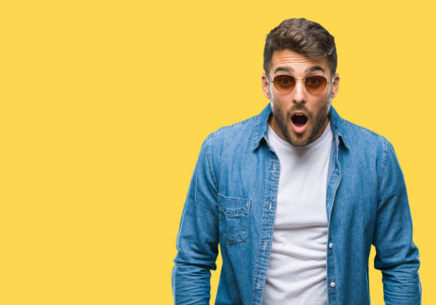 istock Young handsome man wearing sunglasses over isolated background afraid and shocked with surprise expression, fear and excited face. 1042816436