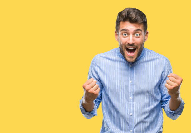 istock Young handsome man over isolated background celebrating surprised and amazed for success with arms raised and open eyes. Winner concept. 1042816476
