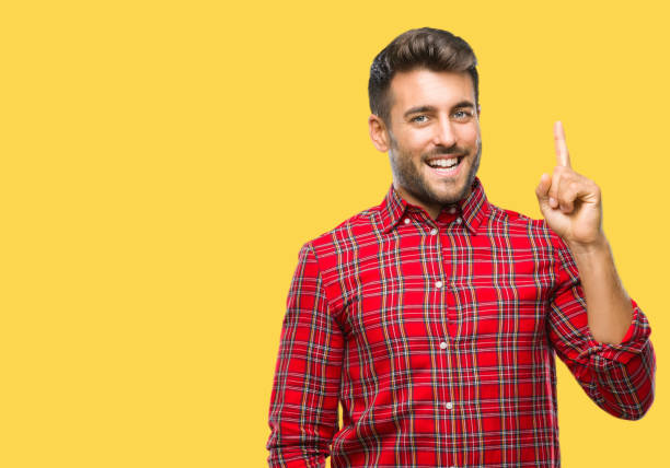 istock Young handsome man over isolated background pointing finger up with successful idea. Exited and happy. Number one. 1042816572