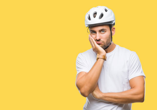istock Young handsome man wearing cyclist safety helmet over isolated background thinking looking tired and bored with depression problems with crossed arms. 1042816722