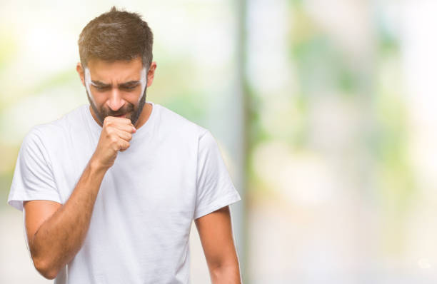 Adult hispanic man over isolated background feeling unwell and coughing as symptom for cold or bronchitis. Healthcare concept. Adult hispanic man over isolated background feeling unwell and coughing as symptom for cold or bronchitis. Healthcare concept. coughing photos stock pictures, royalty-free photos & images