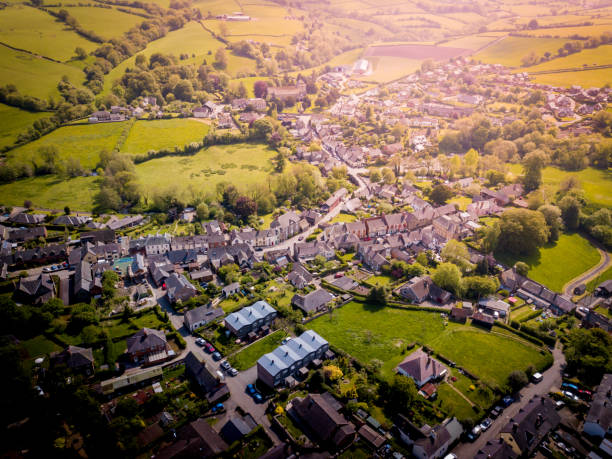 Aerial view of sunrise above an old British village with fields and hills all around. stock photo