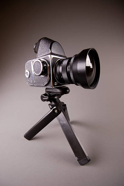 istock Old photo camera with tripod on grey in Hi-Res 104285339