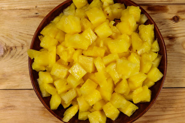 istock Diced pineapple in a plate on wooden table. Top view 1042856696