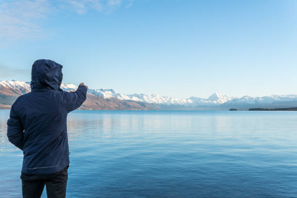 istock Man wearing blue Jacket pointing at Mount Cook 1042860168