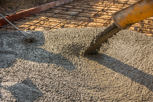 Pouring ready-mixed concrete after placing steel reinforcement to make the road by mixing mobile the concrete mixer.
