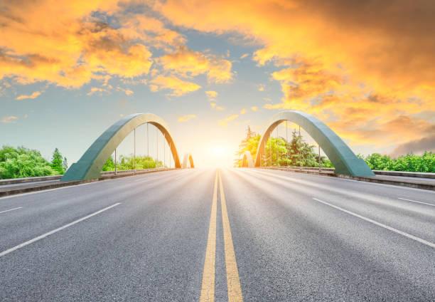 istock Asphalt road and green forest with colorful clouds at sunset 1042868016