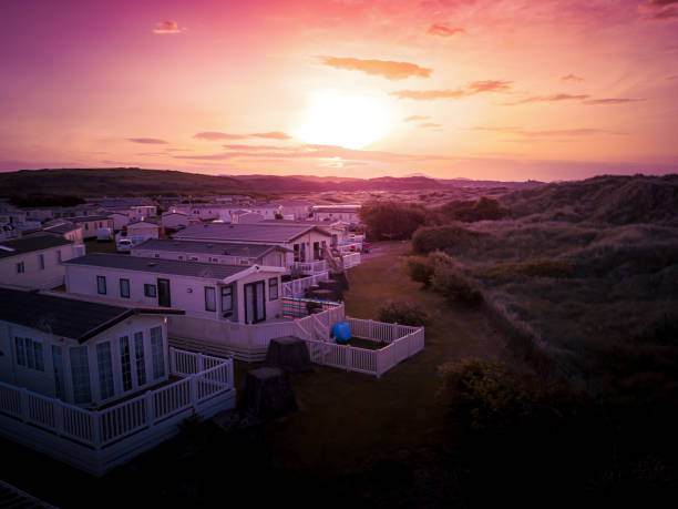 Sun Setting over the sea and Caravan and camping park, static home aerial view. Porthmadog holiday park taken from the air by a drone showing holiday houses and British holiday lifestyle. gwynedd photos stock pictures, royalty-free photos & images