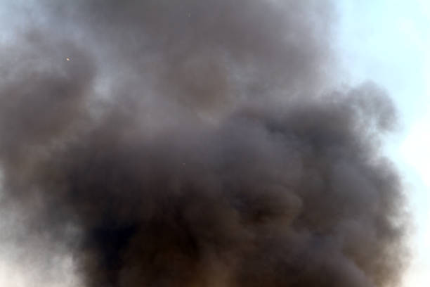 istock black smoke on the blue sky background. 1042870600