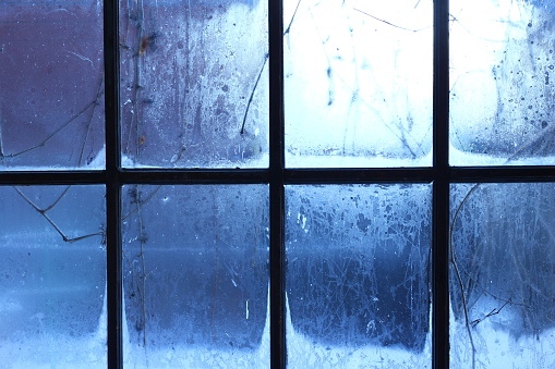 Winter window, drops of water and snowflakes on a window pane.