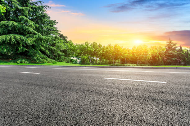 istock Empty asphalt road and green forest with colorful clouds 1042872822