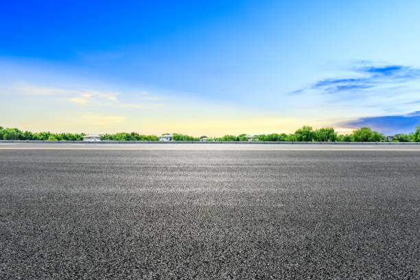 istock Empty asphalt road and green forest with colorful clouds 1042873424