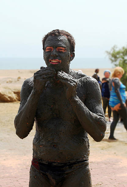 Young man covering himself with mineral mud  people covered in mud stock pictures, royalty-free photos & images
