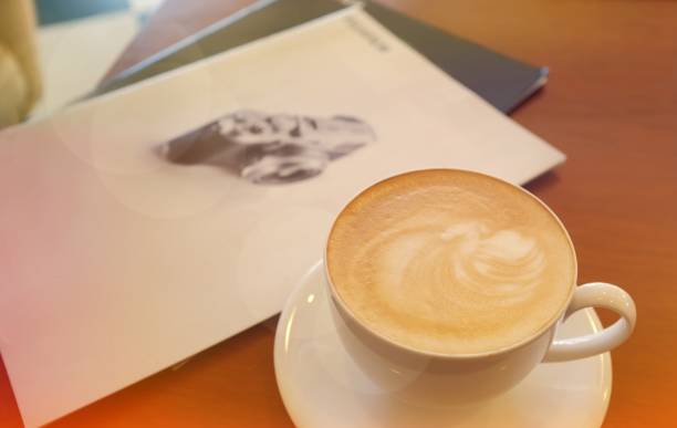 istock capuchino coffee on the table with camera books. 1042882688