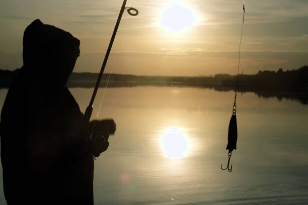 istock Fisherman silhouette at sunset. hobby, sport. 1042882762