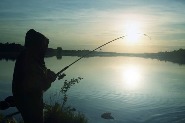 istock Fisherman silhouette at sunset. hobby, sport. 1042882800